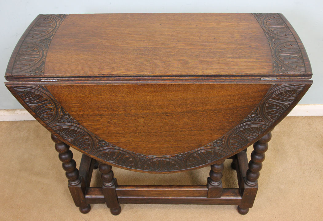 11247r5 Antique Oak Gateleg Side Table, Antique Carved Solid Oak Gateleg Drop Leaf Occasional Table. This solid oak gateleg drop leaf occasional table has a oval top with carved edge detail and is supported by turned bobbin legs and stretchers.