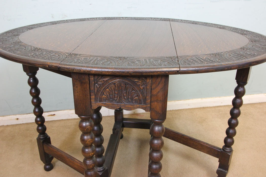 11247r6 Small Antique Oak Gateleg Table, Antique Carved Solid Oak Gateleg Drop Leaf Occasional Table. This solid oak gateleg drop leaf occasional table has a oval top with carved edge detail and is supported by turned bobbin legs and stretchers.