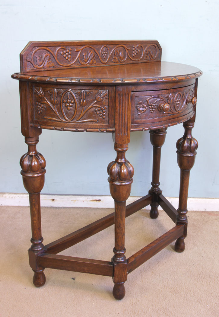 11375r2 Antique Jacobean Style Carved Oak Demi Lune Side Table, Antique Jacobean Style Carved Oak Demi Lune Side Table. This lovely carved oak demi lune / side table has a low carved upstand to the back and carved detail to the top edge