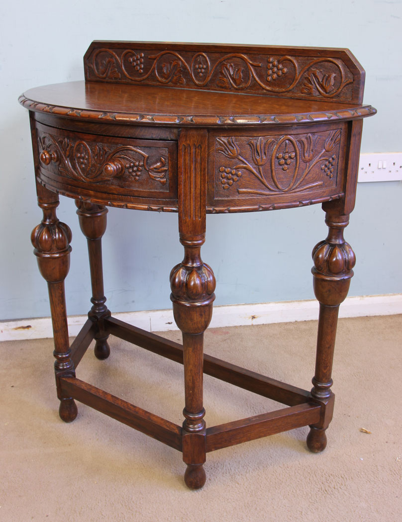 11375r3 Antique Carved Oak Demi Lune Side Table, Antique Jacobean Style Carved Oak Demi Lune Side Table. This lovely carved oak demi lune / side table has a low carved upstand to the back and carved detail to the top edge