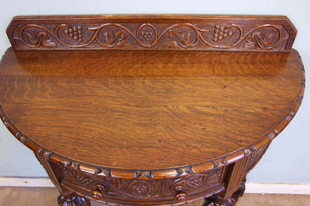 11375r5 Antique Carved Oak Side Table, Antique Jacobean Style Carved Oak Demi Lune Side Table. This lovely carved oak demi lune / side table has a low carved upstand to the back and carved detail to the top edge