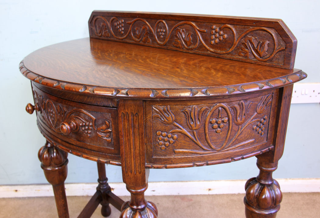 11375r7 Antique Oak Hall Side Table, Antique Jacobean Style Carved Oak Demi Lune Side Table. This lovely carved oak demi lune / side table has a low carved upstand to the back and carved detail to the top edge