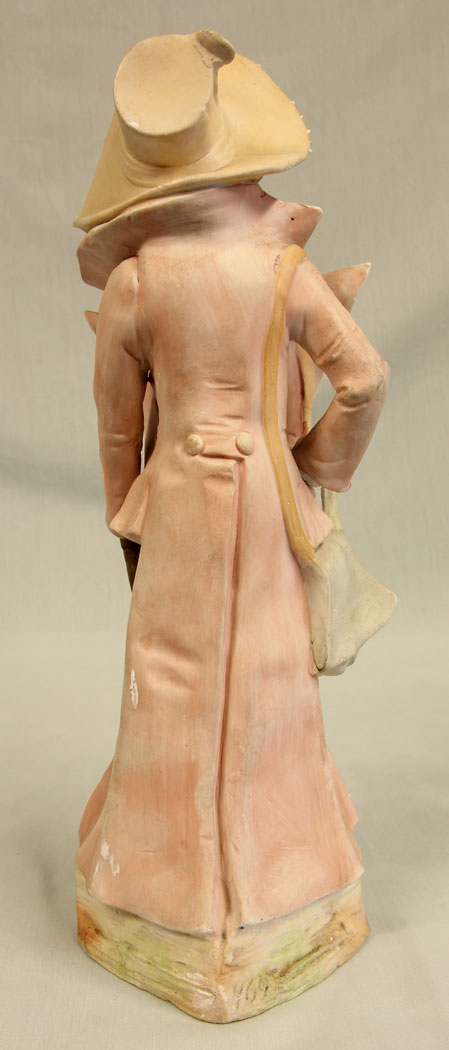 11384r5 Antique Bisque Figurine of Gentleman, Antique Bisque Figurine of Gentleman. This lovely bisque figure of young gentleman is dressed in period clothing and hat all in lovely colours and having hand painted detail with gilt decoration he is holding a bag and a cane. There is a slight chip on the bag see photo. Circa 1900