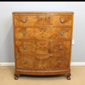 Quality Antique Bow Front Burr Walnut Chest of Drawers. This wonderful quality bow front burr walnut chest of drawers has a lovely burr walnut top with a carved detail edge. Under having four graduated drawers with beautiful burr walnut drawer fronts with carved detail around the base and all supported by short carved cabriole style feet. All In Very Good Condition. Circa 1930